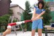 A woman holding a baseball bat and a ball.