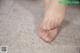 A close up of a person's bare feet on a carpet.