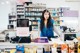 A woman standing behind a counter in a pharmacy.