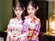 Two young women in kimonos standing next to each other.