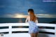 A woman in a blue and white dress standing on a balcony.