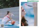 A woman sitting on a basketball court drinking water from a bottle.