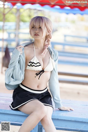 A woman in a bikini sitting on a bench.